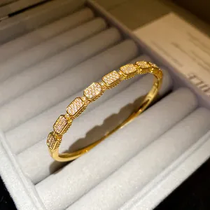 Detail shot of 18K gold plated bangle with sparkling cubic zirconia in jewelry box.