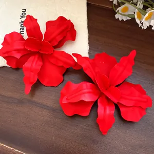 Detailed view of red spray-painted flower stud earrings with steel pins.