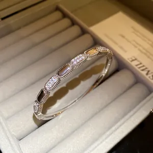 Close-up detail of 18K silver-plated oval link bangle with pavé-set cubic zirconia stones