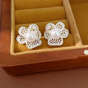 Detailansicht der silberfarbenen Ohrstecker in Blumenform mit Zirkonia und Perlen
