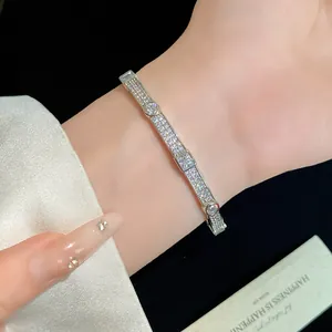 Detailed close-up of 18K gold plated bracelet with pave zircon and geometric stones
