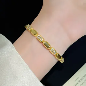 Close-up of elegant 18K gold plated oval link bracelet with pavé zircons on wrist