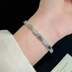 Detailed close-up of an 18K gold plated bracelet with sparkling zircon inlaid oval links.