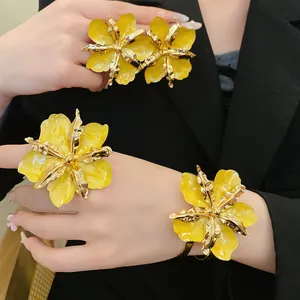 Vue détaillée de bijoux fleurs plissées jaunes avec bords métalliques dorés