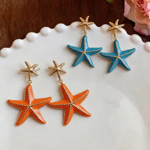 Elegant starfish enamel drop earrings in orange and blue with silver needles for beach vacation.