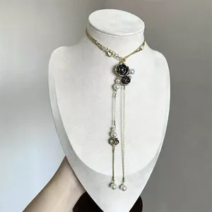 Close-up of vintage double-layer necklace with black rose and pearl tassels