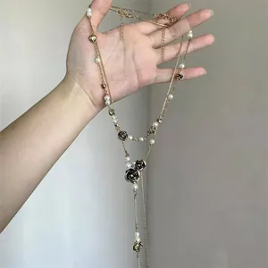Detailed view of vintage double-layer necklace featuring black roses and elegant pearls finish