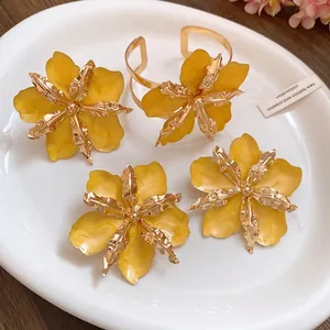 Vue détaillée des boucles d'oreilles et du bracelet fleurs jaunes sur une assiette
