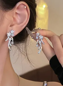 Close-up detail showing exquisite silver shooting star ear clips with sparkling zircon stones