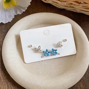 Elegant butterfly and blue flower stud earrings set with rhinestones and enamel finish.
