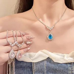 Detailed view of sparkling rhinestone waterdrop pendant necklace worn by a model.