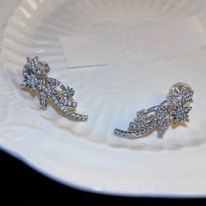 Detailed macro shot of silver meteor clip-on earrings with shimmering cubic zirconia stones.