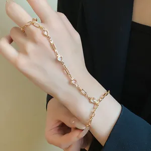 Elegant gold chain hand harness featuring resin heart and rectangular crystal charms on model
