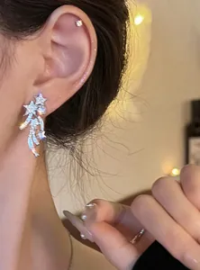 Close-up of zircon meteor clip-on earrings on ear, showcasing elegant silver design