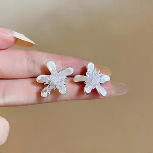 Detailed macro shot showing the delicate white flower petals and glass center of these earrings