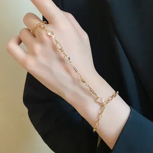 Close-up of a vintage-style gold hand harness featuring delicate resin hearts and links.