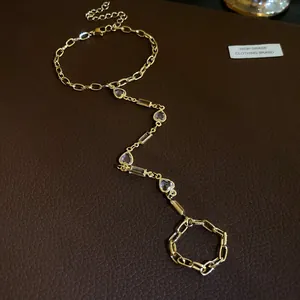 Vintage style gold hand chain with heart resin charms and crystal details on leather
