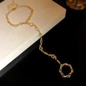 Minimalist vintage gold hand chain bracelet featuring clear heart resin charms and ring