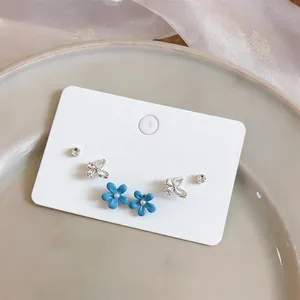 Detail view of a 3-pair earring set with blue flowers, butterflies, and rhinestones