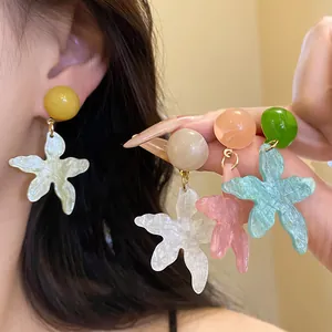 Detail view of colorful resin star flower earrings in various summery pastel shades