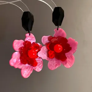 Detailed view of vintage acrylic flower earrings with vibrant pink and red layered petals