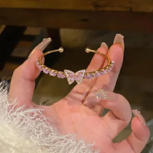 Exquisite gold open cuff bracelet featuring a pink zircon butterfly and teardrop stones