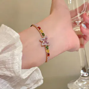 Close-up of elegant French style gold butterfly bracelet with colorful teardrop zircon stones