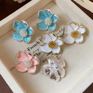 Vue détaillée de divers clips d'oreilles floraux colorés dans un plateau à bijoux