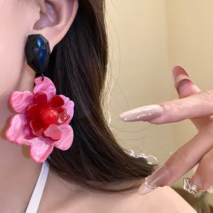 Close-up detail of vintage style layered pink acrylic flower drop earrings on model