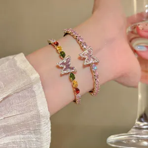 Close-up of two elegant French light luxury butterfly bangles with colorful zircons.