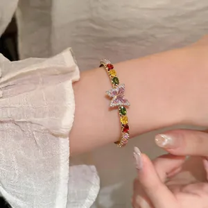 Detailed view of an elegant French style butterfly open bangle featuring colorful stones
