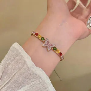 Close-up of French luxury bracelet featuring colorful zircons and a sparkling butterfly charm.