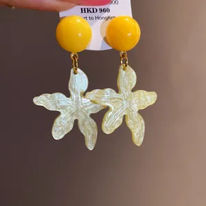Close-up of yellow resin starfish earrings for summer beach vacation style