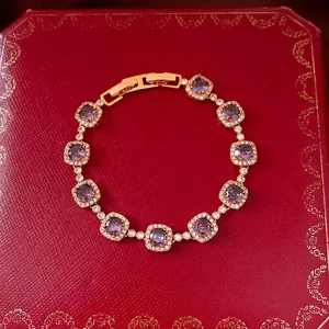 Élégant bracelet plaqué or avec zircons carrés violets sur un coffret cadeau rouge de luxe