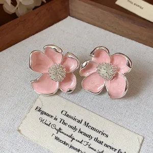 Vue détaillée de boucles d'oreilles fleurs en émail rose élégantes avec finition argentée