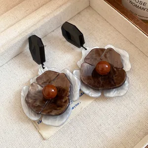 Close-up view of vintage acrylic flower drop earrings featuring elegant tortoiseshell texture