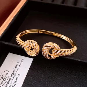 Detailed view of elegant 18K gold-plated open bangle featuring sparkling zircon-set twisted knots.
