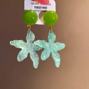 Detailed close-up of elegant summer beach resin starfish flower earrings with glitter