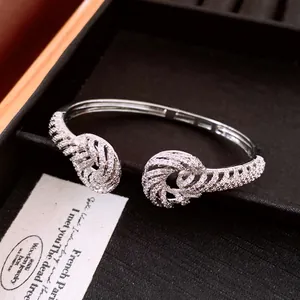 Close-up of luxury 18K gold plated twisted bangle with shimmering cubic zirconia