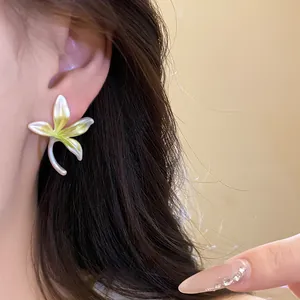 Close-up detail view of a forest-style orchid flower stud earring worn on an ear