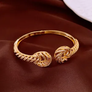 Macro detail of 18K gold plated twisted open bangle with sparkling zirconia stones
