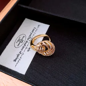 Close-up view of a golden twisted texture ring featuring elegant sparkling zircon inlay