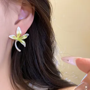 Close-up of a delicate lily flower earring with a green and white gradient finish