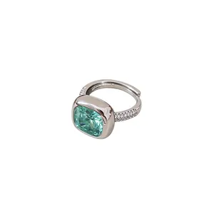 Élégante bague en argent ornée d'un zircon vert taille coussin et d'accents pavés.