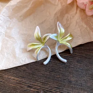 Close-up macro view of forest-style flower earrings with green gradient petal finish