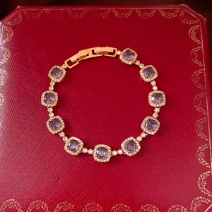 Vue macro d'un bracelet en plaqué or avec des zircons violets de forme carrée