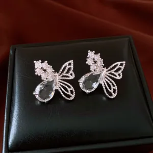 Gros plan sur d'élégantes boucles d'oreilles papillon en argent et pierres