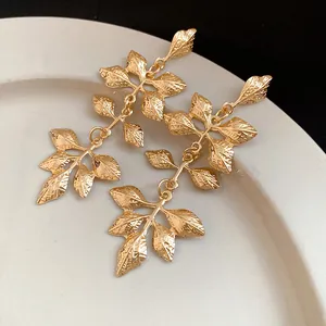Gros plan détaillé de boucles d'oreilles vintage élégantes en forme de feuille dorée