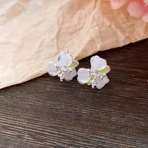 Close-up view of delicate forest-style flower earrings with small crystal accents