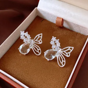 Gros plan de boucles d'oreilles papillon élégantes avec zircons dans un joli coffret